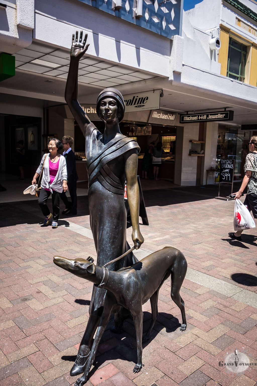 Une  dame promène son chien. Oeuvre commandée par la ville en 2009 prenant pour modèle la fille d'un des architectes de la reconstruction Art Déco de la ville.